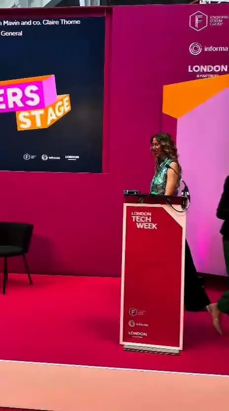 Reel: a speaker at a lectern on a pink conference stage at London Tech Week