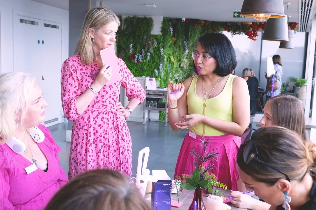 Rebecca leading a discussion with women around a workshop table