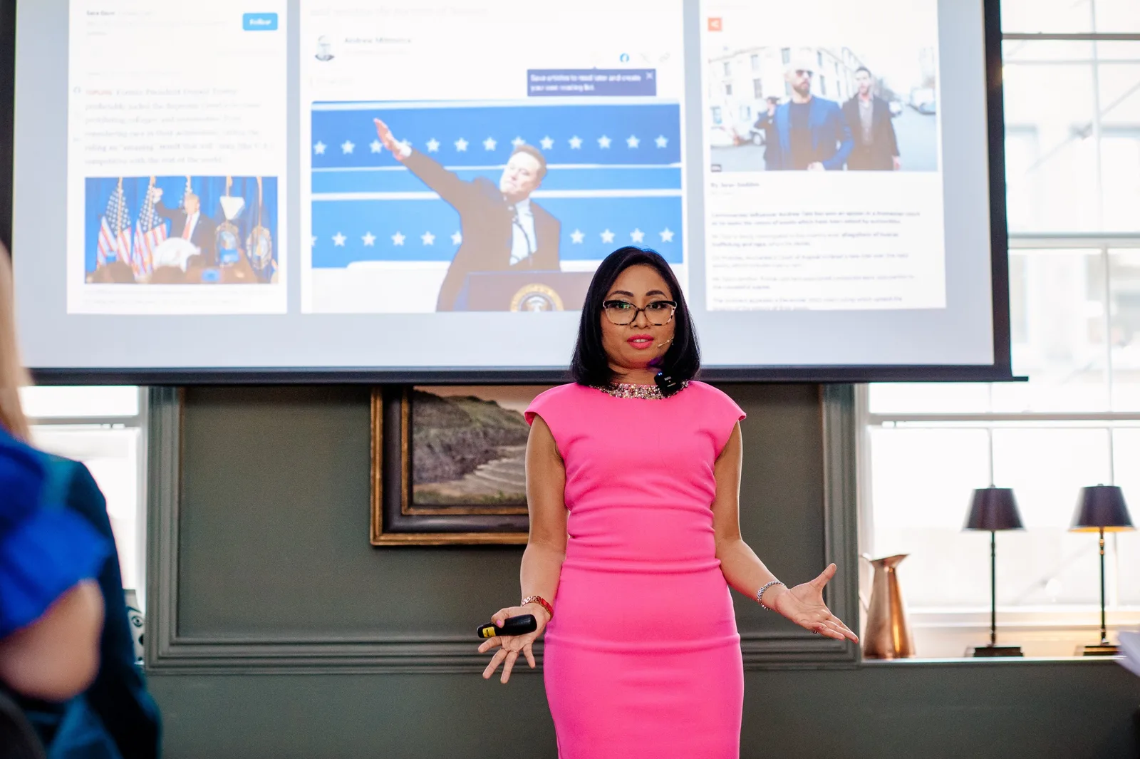 Rebecca in a pink dress presenting in front of a projected slide